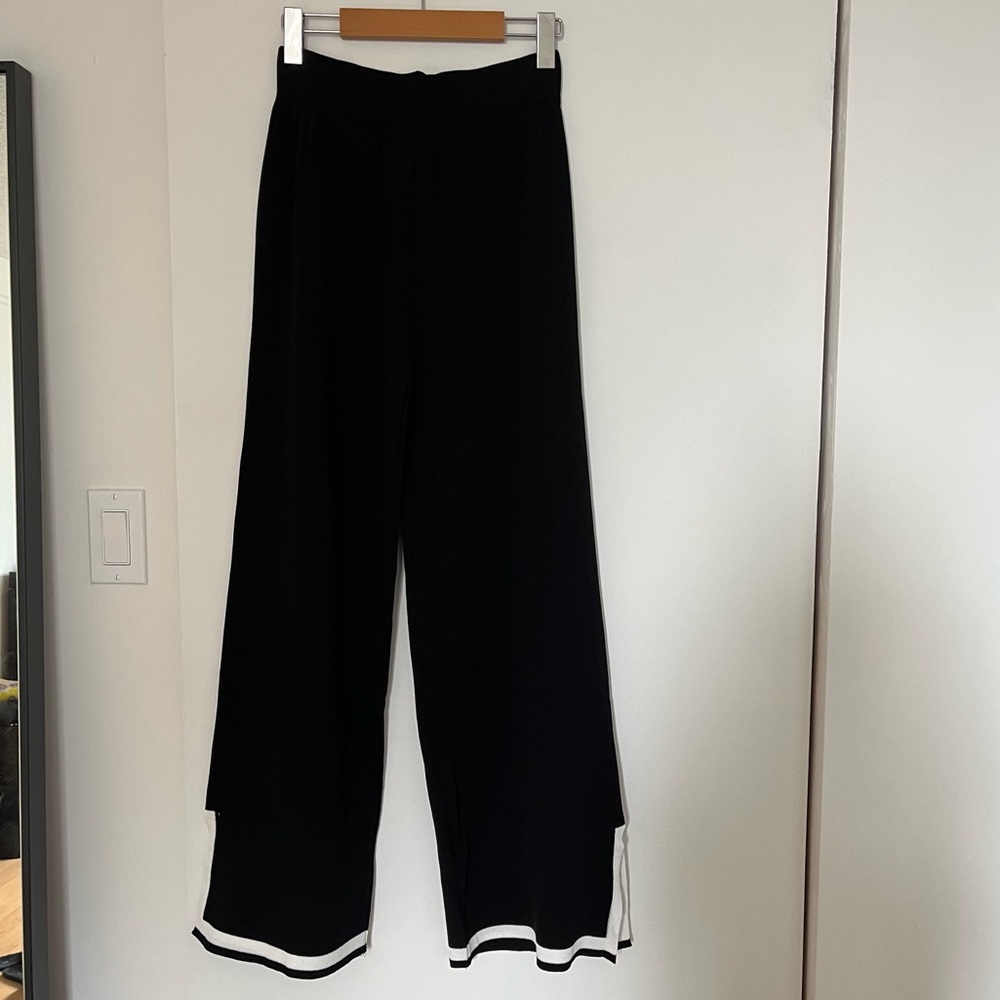 Black sweater pants with white trim and slit on the side